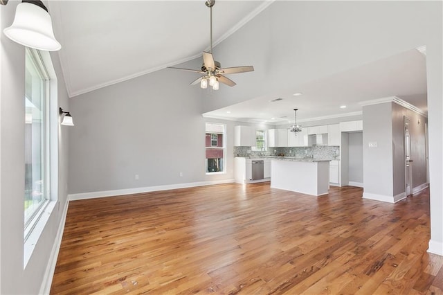 unfurnished living room featuring ornamental molding, light wood finished floors, a ceiling fan, baseboards, and recessed lighting