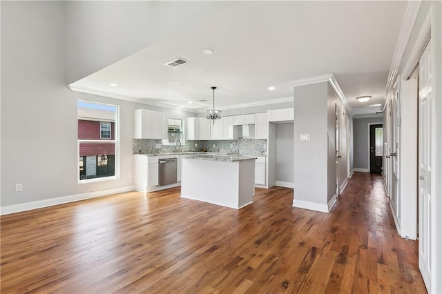 kitchen featuring crown molding, dishwasher, a kitchen island, decorative backsplash, and white cabinets