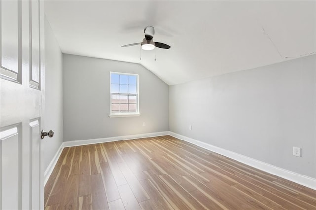 bonus room with a ceiling fan, lofted ceiling, wood finished floors, and baseboards