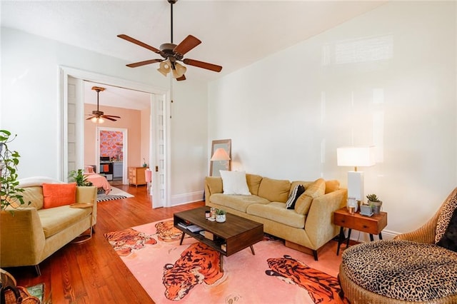 living room with a ceiling fan, wood finished floors, and baseboards