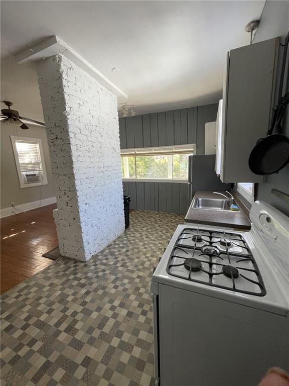 kitchen with gas stove, a sink, a ceiling fan, tile patterned floors, and freestanding refrigerator
