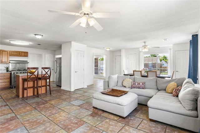 5801 Ruth St, Metairie, LA 70003 - living room with ceiling fan, plenty of natural light, and stone tile flooring