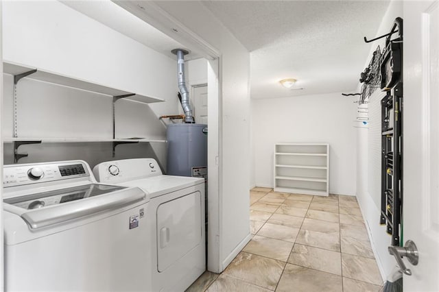 washroom with independent washer and dryer, water heater, light marble finish floors, baseboards, and a textured ceiling