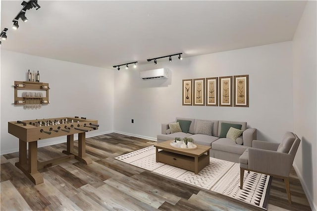 5801 Ruth St, Metairie, LA 70003 - living room featuring rail lighting, an AC wall unit, and wood finished floors