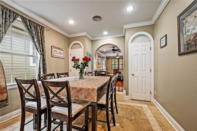 dining area featuring inlaid floor details, baseboards, recessed lighting, crown molding, and arched walkways