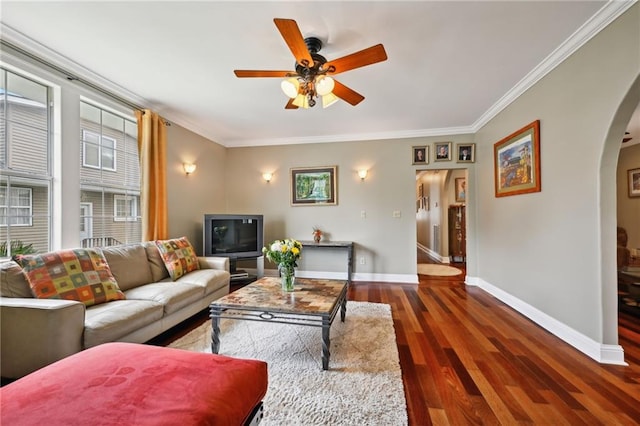 living room featuring arched walkways, crown molding, ceiling fan, dark wood finished floors, and baseboards