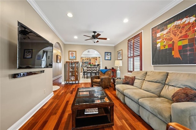 living room featuring arched walkways, ceiling fan, recessed lighting, wood finished floors, and crown molding