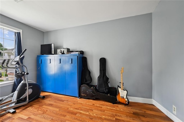 exercise area featuring wood finished floors and baseboards