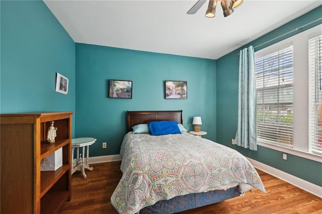 bedroom featuring baseboards, wood finished floors, and ceiling fan