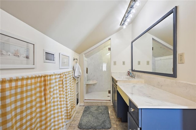 full bath featuring lofted ceiling, a shower stall, vanity, and tile patterned flooring
