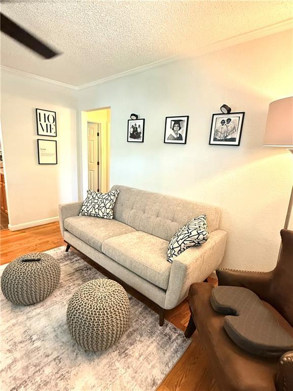 4560 Laine Ave, New Orleans, LA 70126 - living room with light wood-style floors, a textured ceiling, and crown molding