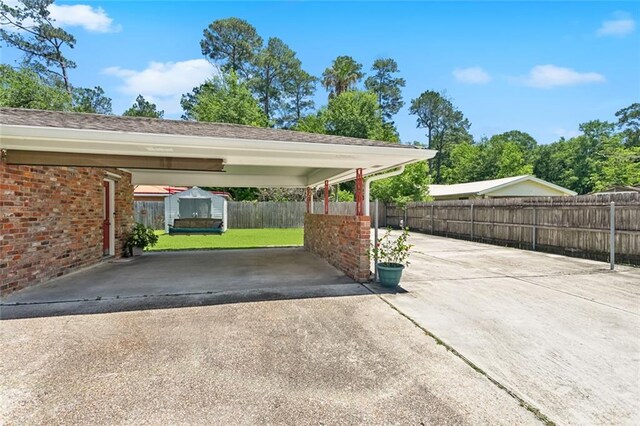 1207 Cousin St, Slidell, LA 70458 - view of parking / parking lot featuring asphalt driveway and a carport