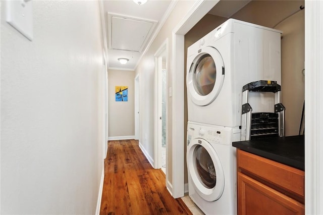 1207 Cousin St, Slidell, LA 70458 - laundry area featuring stacked washer / dryer, attic access, wood finished floors, and ornamental molding