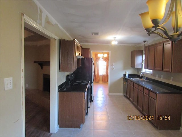 7812 Scottwood Dr, New Orleans, LA 70128 - kitchen with dark countertops, a chandelier, a fireplace, a sink, and light tile patterned flooring