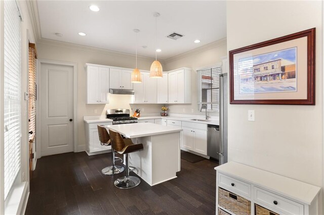 110 Sharon Dr, New Orleans, LA 70124 - kitchen featuring appliances with stainless steel finishes, under cabinet range hood, a sink, dark wood finished floors, and ornamental molding