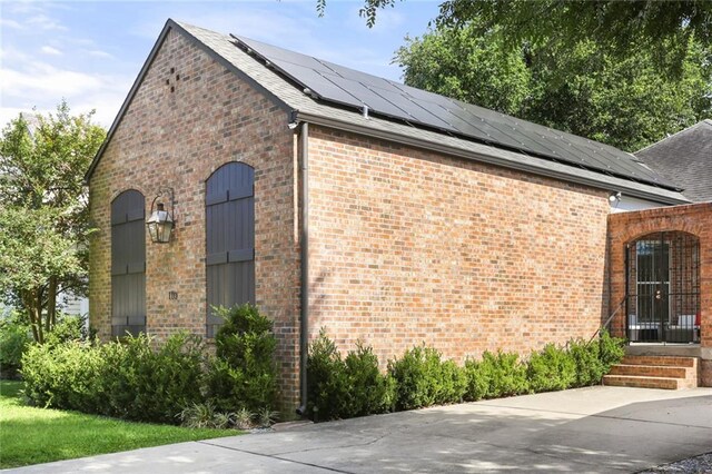 110 Sharon Dr, New Orleans, LA 70124 - view of side of home featuring solar panels, brick siding, and a shingled roof