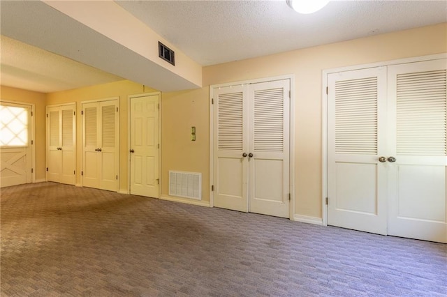 20408 Smith Rd, Covington, LA 70435 - unfurnished bedroom with two closets, carpet floors, and a textured ceiling