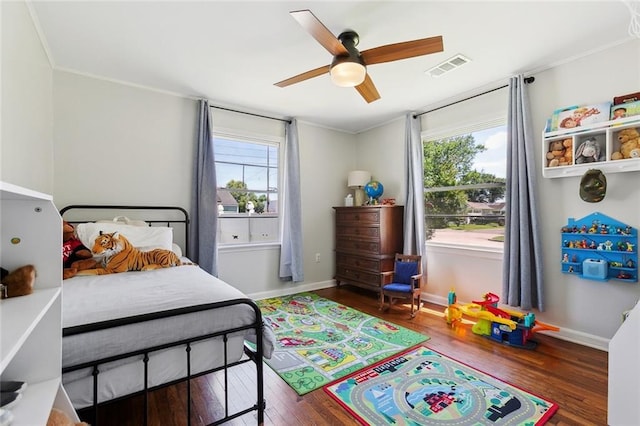 bedroom with wood finished floors, baseboards, crown molding, and ceiling fan