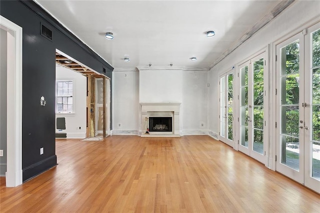 1215 Exposition Blvd, New Orleans, LA 70118 - unfurnished living room featuring light wood-style floors, baseboards, a fireplace with raised hearth, and ornamental molding
