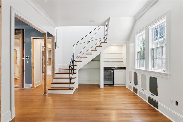1215 Exposition Blvd, New Orleans, LA 70118 - staircase featuring wine cooler, wood finished floors, a bar, and baseboards