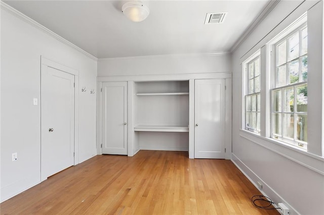 1215 Exposition Blvd, New Orleans, LA 70118 - unfurnished bedroom with light wood-style floors, crown molding, and a closet