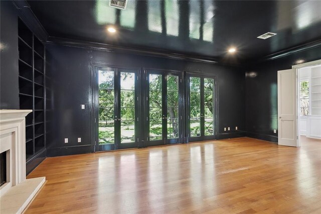 1215 Exposition Blvd, New Orleans, LA 70118 - unfurnished living room with built in features, ornamental molding, a fireplace with raised hearth, light wood-style floors, and recessed lighting