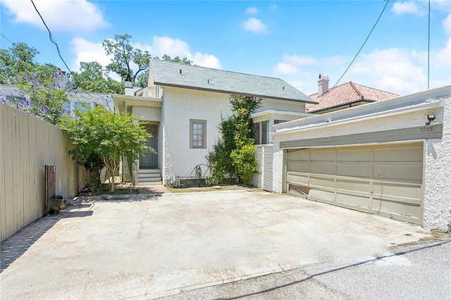 1215 Exposition Blvd, New Orleans, LA 70118 - rear view of house featuring stucco siding, driveway, and a garage