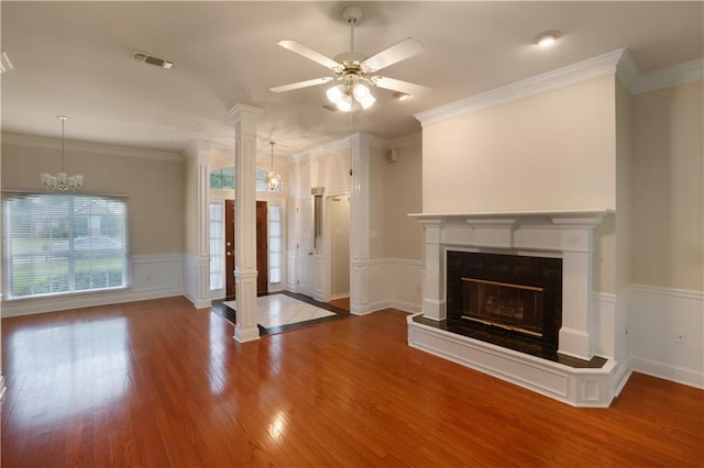 910 Crestwood Blvd, Covington, LA 70433 - unfurnished living room featuring wood finished floors, a ceiling fan, decorative columns, a premium fireplace, and wainscoting