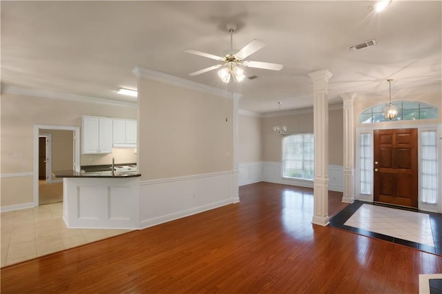 910 Crestwood Blvd, Covington, LA 70433 - entrance foyer featuring a chandelier, decorative columns, crown molding, ceiling fan, and a wainscoted wall