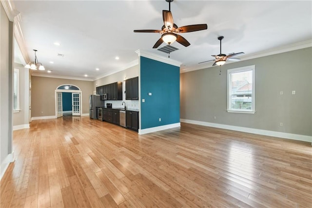 unfurnished living room featuring light wood-style floors, crown molding, a chandelier, ceiling fan, and recessed lighting
