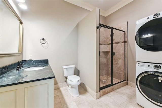 bathroom with stacked washing machine and dryer, a shower stall, toilet, baseboards, and vanity