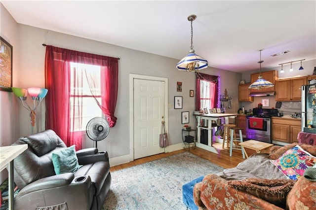 living area featuring light wood-type flooring and baseboards