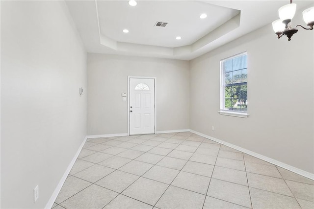 3725 Clermont Dr, New Orleans, LA 70122 - spare room featuring a tray ceiling, baseboards, recessed lighting, a chandelier, and light tile patterned flooring