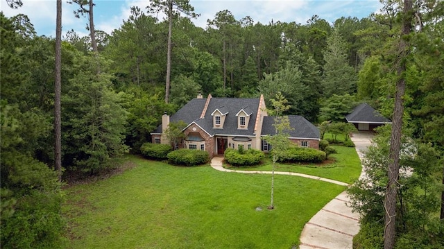 324 Salem Dr, Mandeville, LA 70471 - view of front facade with a wooded view, a front lawn, concrete driveway, and a chimney