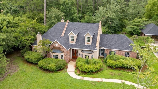 324 Salem Dr, Mandeville, LA 70471 - view of front of house with a chimney, a front lawn, brick siding, and a wooded view
