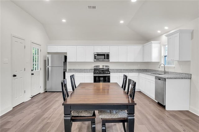 172 Winnona Dr, Westwego, LA 70094 - kitchen with appliances with stainless steel finishes, vaulted ceiling, a sink, plenty of natural light, and light wood-type flooring