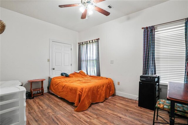 52125 Oak Ridge Dr, Franklinton, LA 70438 - bedroom with wood finished floors, baseboards, a ceiling fan, and multiple windows