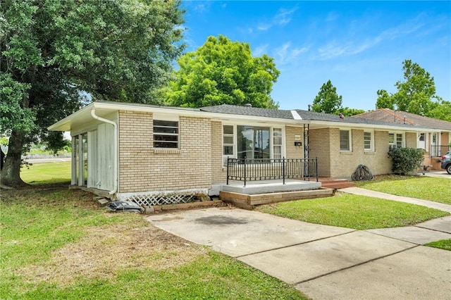 ranch-style home featuring brick siding and a front lawn