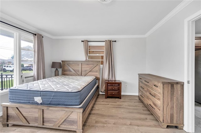 bedroom with baseboards, light wood finished floors, crown molding, and access to outside