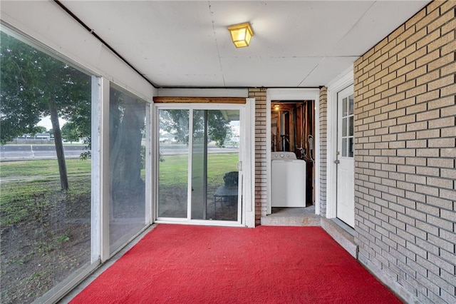unfurnished sunroom featuring washer / dryer