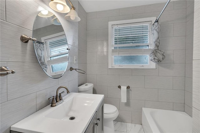 full bathroom with tile walls, marble look tile flooring, toilet, vanity, and shower / bath combination with curtain