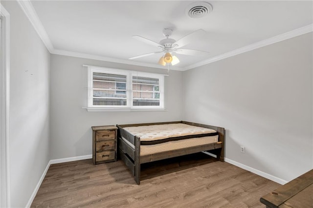 bedroom with wood finished floors, baseboards, ornamental molding, and ceiling fan