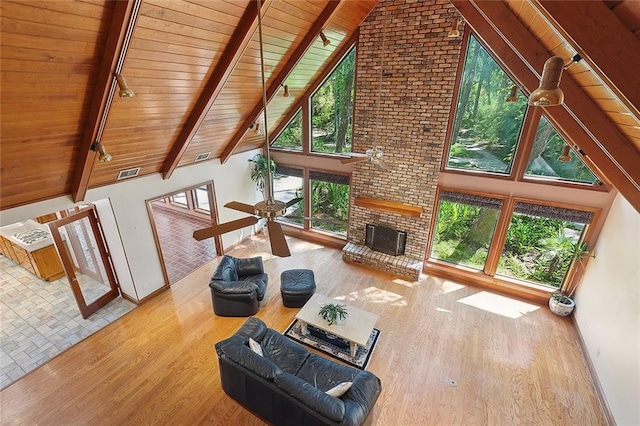 201 Natchez Pl, Mandeville, LA 70471 - unfurnished living room with wood ceiling, rail lighting, a brick fireplace, baseboards, and high vaulted ceiling