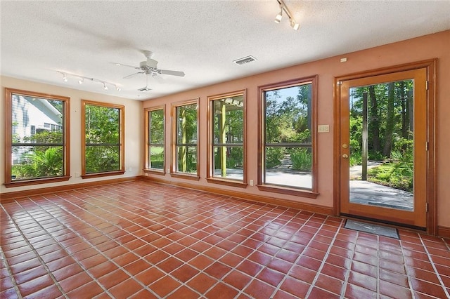 201 Natchez Pl, Mandeville, LA 70471 - unfurnished sunroom with rail lighting, a textured ceiling, tile patterned floors, and baseboards
