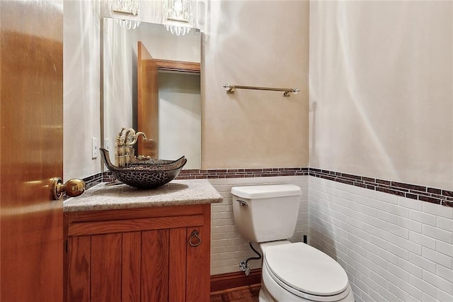 201 Natchez Pl, Mandeville, LA 70471 - half bathroom with tile walls, a wainscoted wall, toilet, and vanity