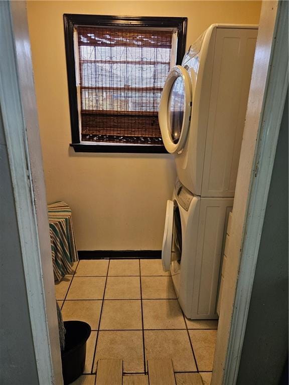 1309 Independence St, New Orleans, LA 70117 - clothes washing area with stacked washer / drying machine, light tile patterned floors, healthy amount of natural light, and baseboards