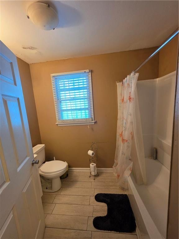 1309 Independence St, New Orleans, LA 70117 - bathroom featuring toilet and shower / bathtub combination with curtain