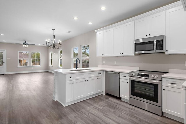 70405 9th St, Covington, LA 70433 - kitchen featuring stainless steel appliances, a sink, a chandelier, a peninsula, and recessed lighting
