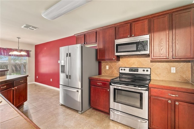 28475 Apple Blossom Ln, Ponchatoula, LA 70454 - kitchen featuring stainless steel appliances, decorative backsplash, hanging light fixtures, a chandelier, and baseboards