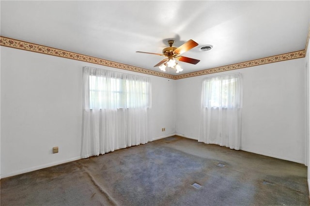 spare room featuring healthy amount of natural light, carpet floors, a ceiling fan, and baseboards